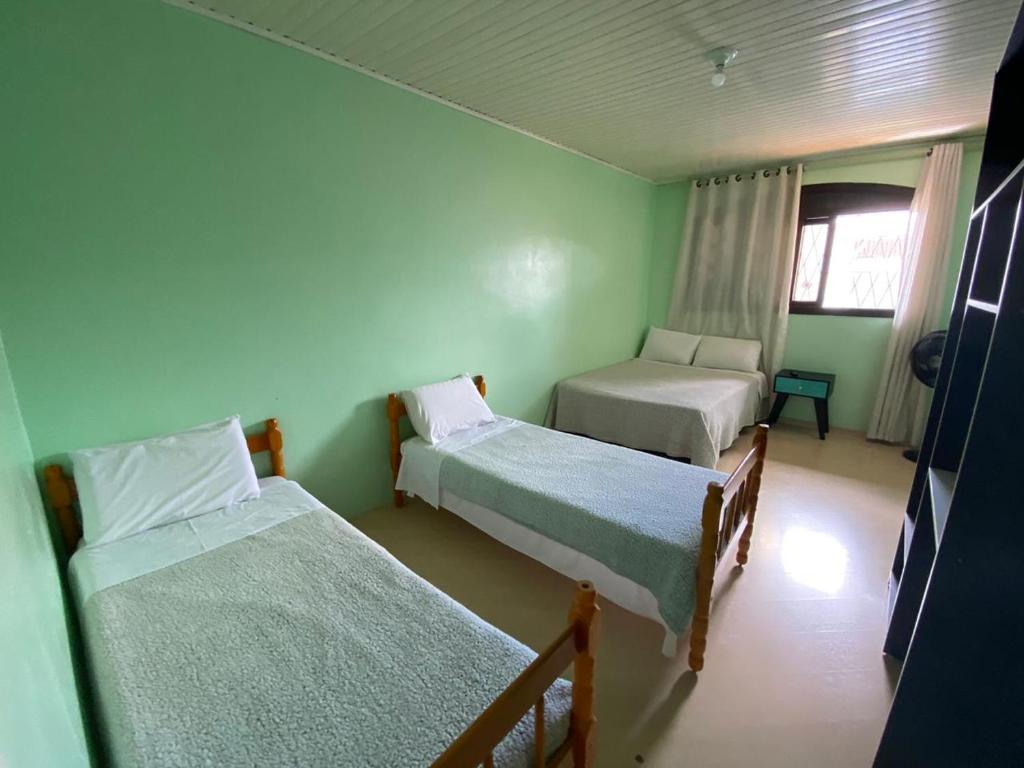 a small room with two beds and a window at Pousada 355 in Passo Fundo