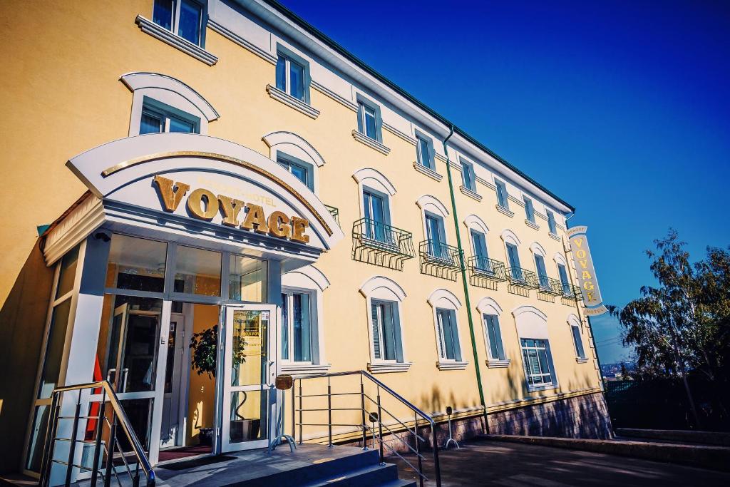 a yellow building with a voodoo sign on it at Voyage Hotel in Penza