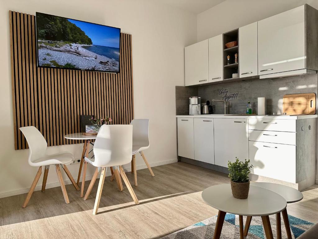 eine Küche mit weißen Schränken und einem Tisch und Stühlen in der Unterkunft Haus Concordia 2 Möwennest in Thiessow