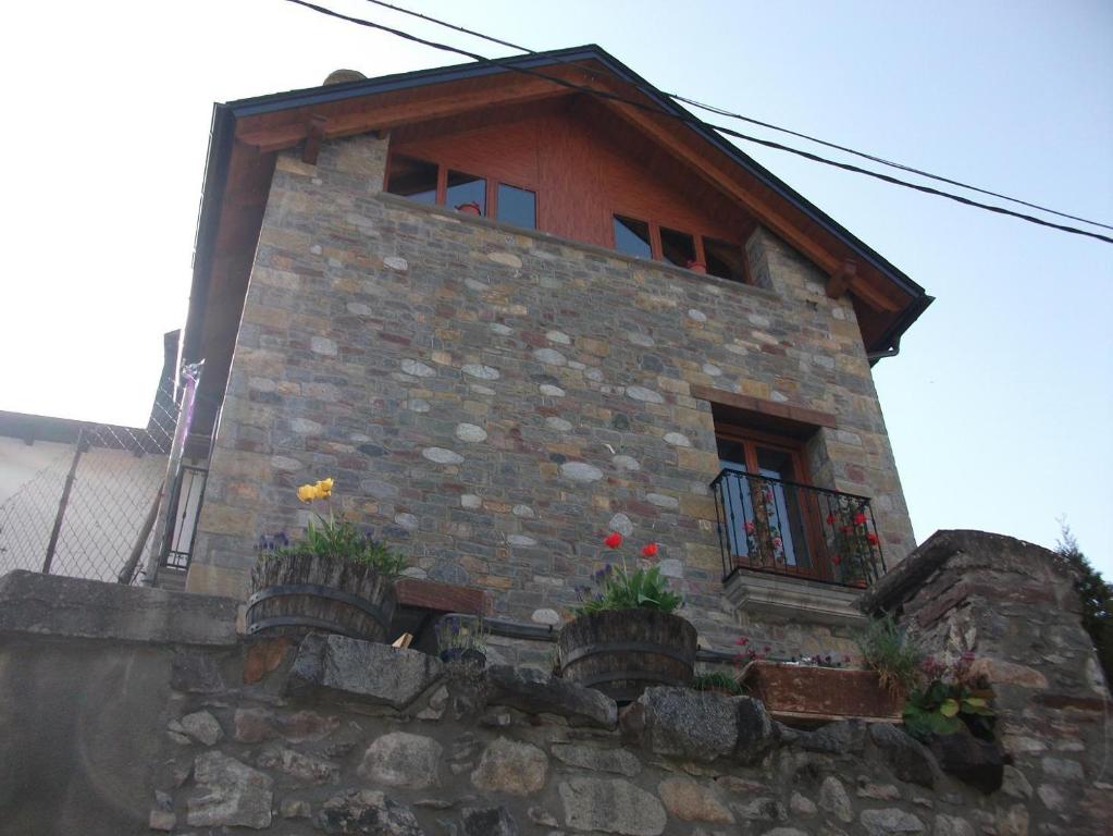 a building with potted plants on a stone wall at Casa La Bordeta Remondillo in San Juan de Plan