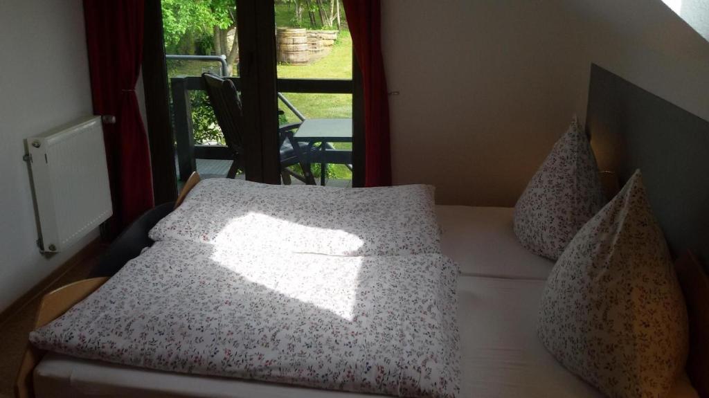 a bedroom with a bed with pillows and a window at Wohnung mit Balkon und Blick auf die Weinberge in Kröv
