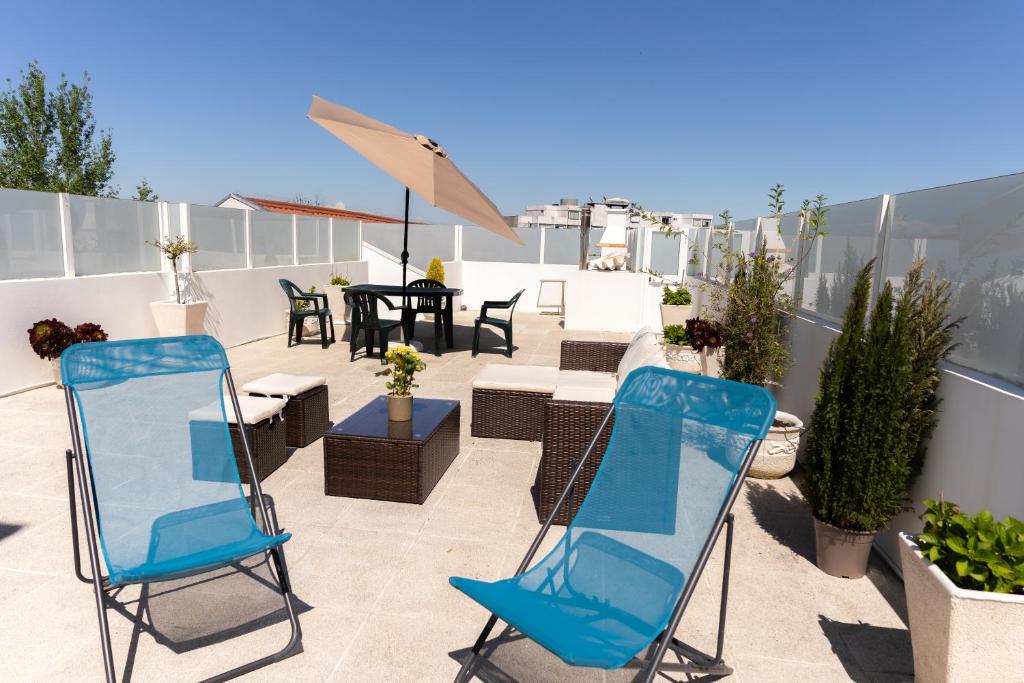 a patio with chairs and a table on a roof at Douro Garden & Rooftop Home in Vila Nova de Gaia