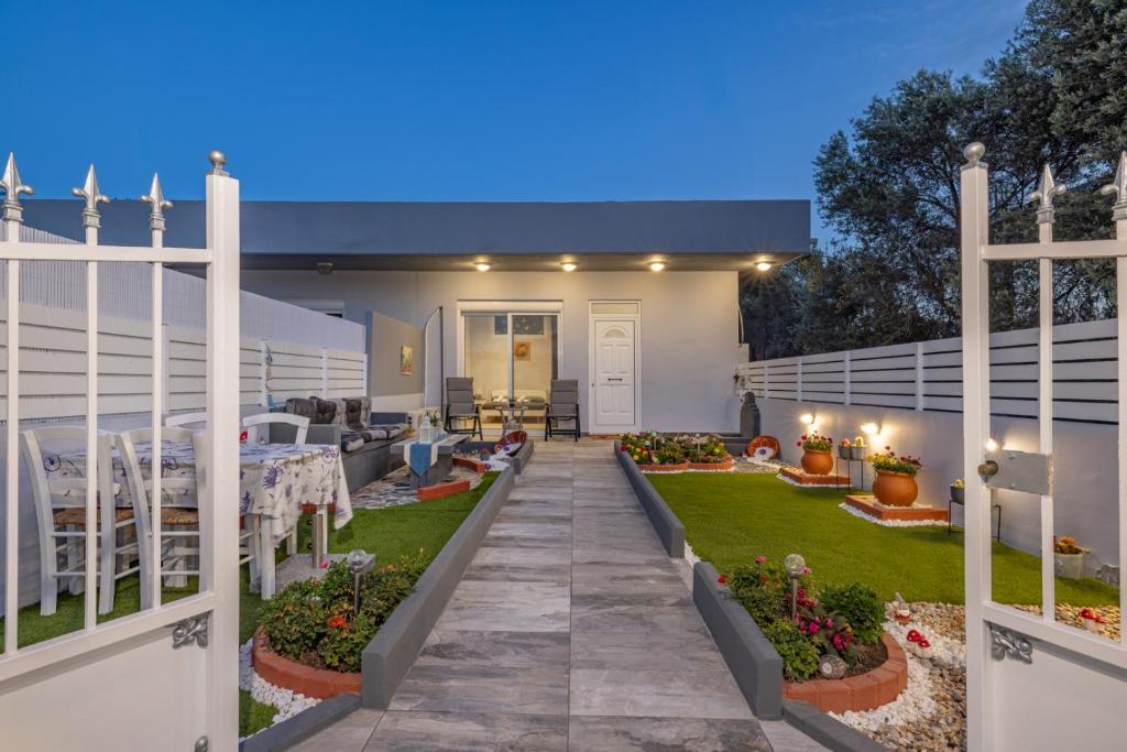 a patio with a table and chairs in a yard at Rania's House Faliraki in Faliraki