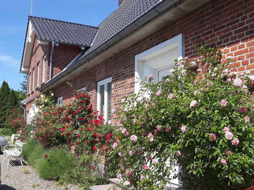 a brick house with flowers in front of a window at Ferienwohnung in Stoltebüll mit Kleiner Terrasse in Stoltebüll