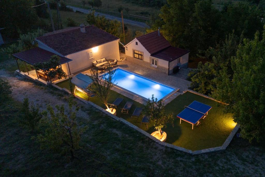 an overhead view of a house with a swimming pool at night at Family Little Paradise in Ružić