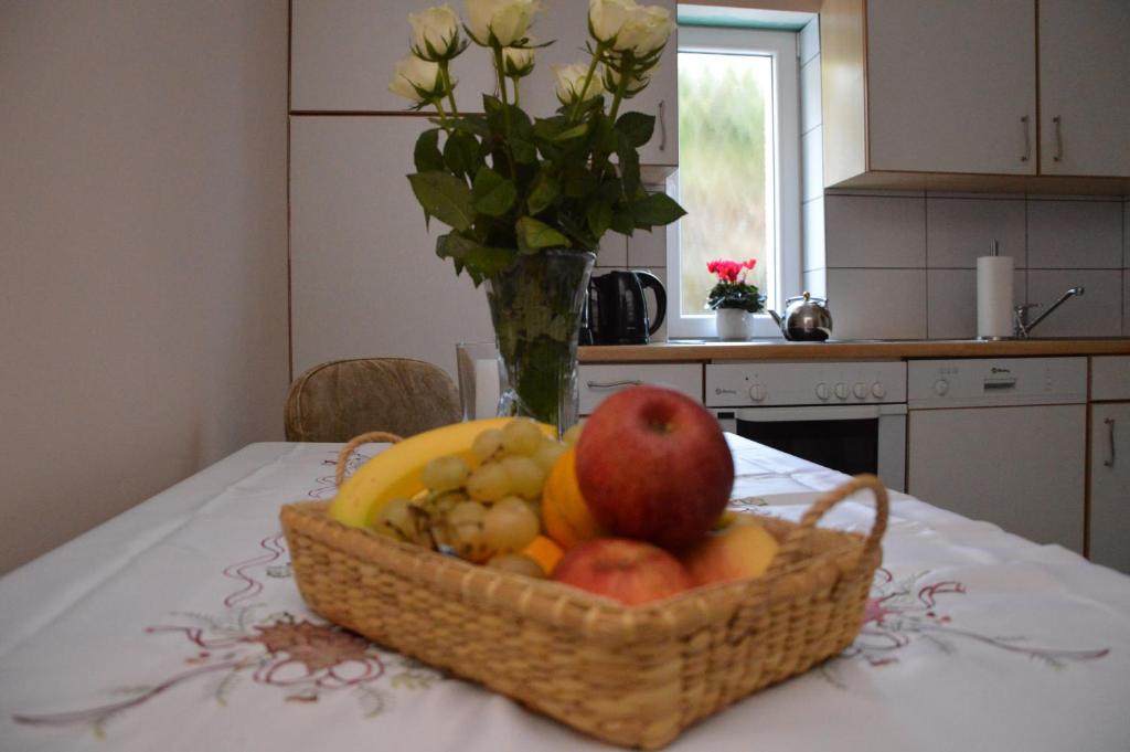 una cesta de fruta en una mesa con un jarrón de flores en Private Room Pyrkerstraße, en Bad Hofgastein