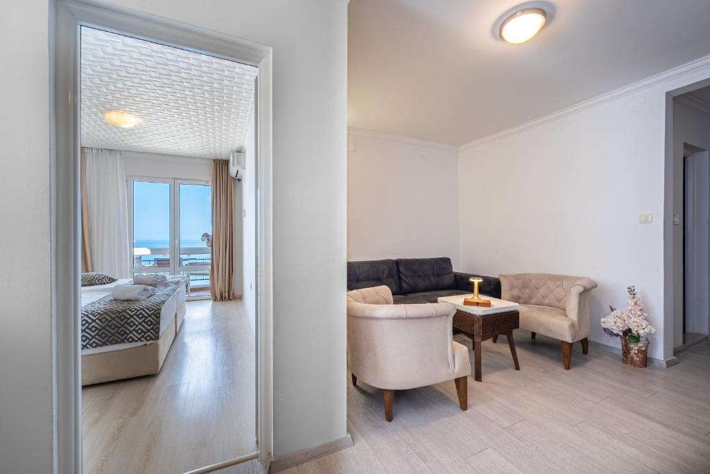 a bedroom and a living room with a bed and a table at Hotel Adrović in Sveti Stefan