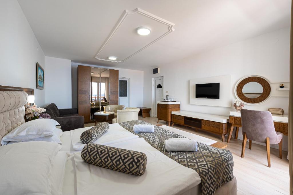 a bedroom with two beds and a living room at Hotel Adrović in Sveti Stefan