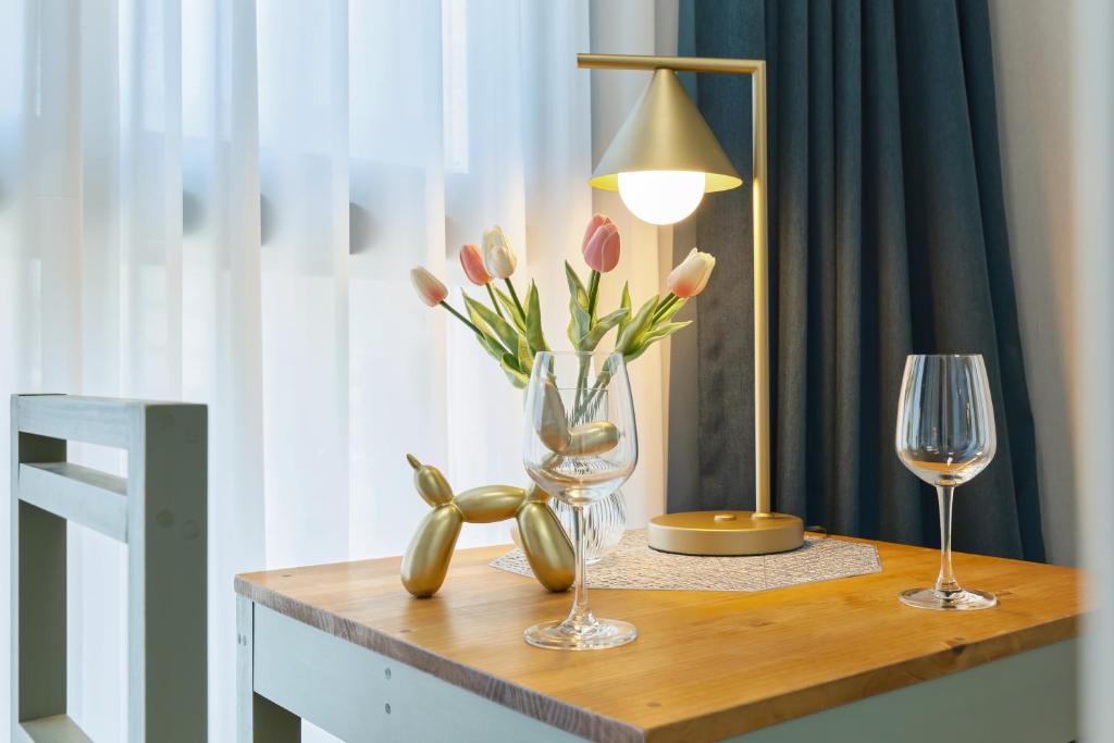 a table with two wine glasses and a vase of flowers at Seoul COMOCASA Fully Furnished Studio in Seoul