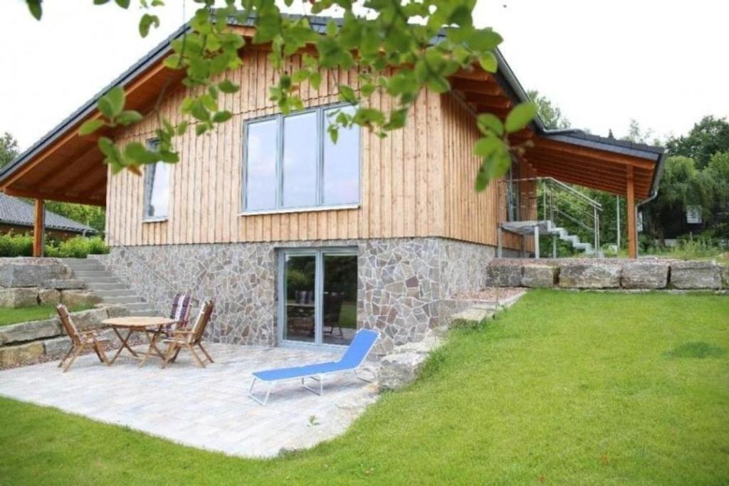 a house with a blue chair and a table at Moderne Luxusvilla in Naturlage am Miltenberg, modernes Interieur, Profiküche in Miltenberg