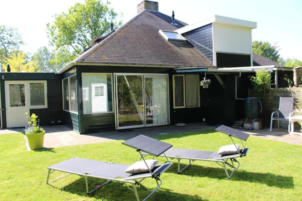 a backyard with two lounge chairs and a house at Ferienhaus in Stavenisse mit Garten, Grill und Terrasse in Stavenisse