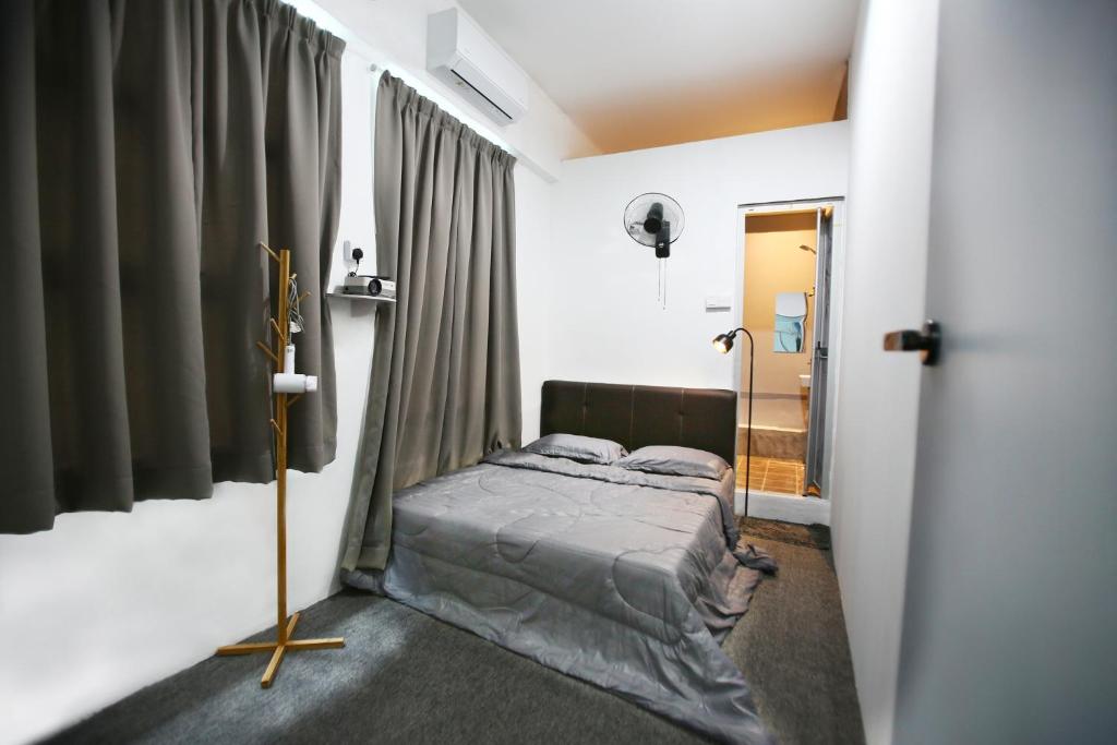 a bedroom with a bed in a room with curtains at HangoutSpacez Queensbay at Bayan Lepas Penang in Bayan Lepas