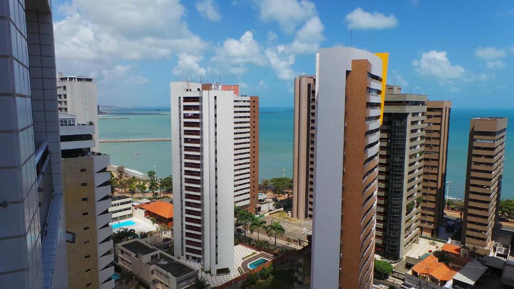 uma vista para uma cidade com edifícios altos e o oceano em Emilio Hinko 3 Quartos apto1502 em Fortaleza