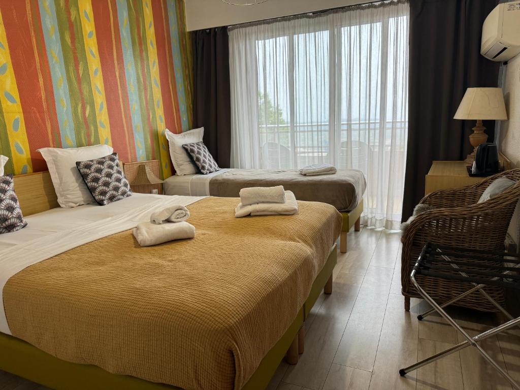 a hotel room with two beds and a window at Hotel Panorama in Grasse