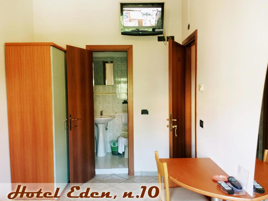Habitación con mesa y baño con lavabo. en Hotel Eden, en Milán