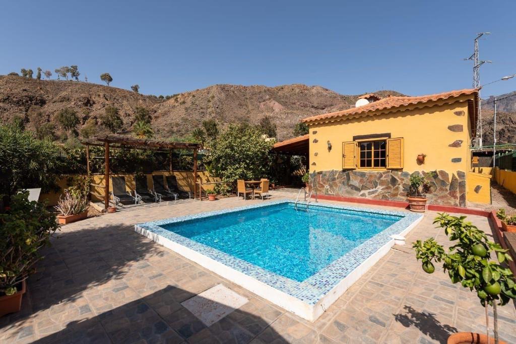ein Swimmingpool vor einem Haus in der Unterkunft Liebevoll eingerichtetes und geräumiges Ferienhaus mit großem Garten und einem privaten Pool in San Bartolomé de Tirajana