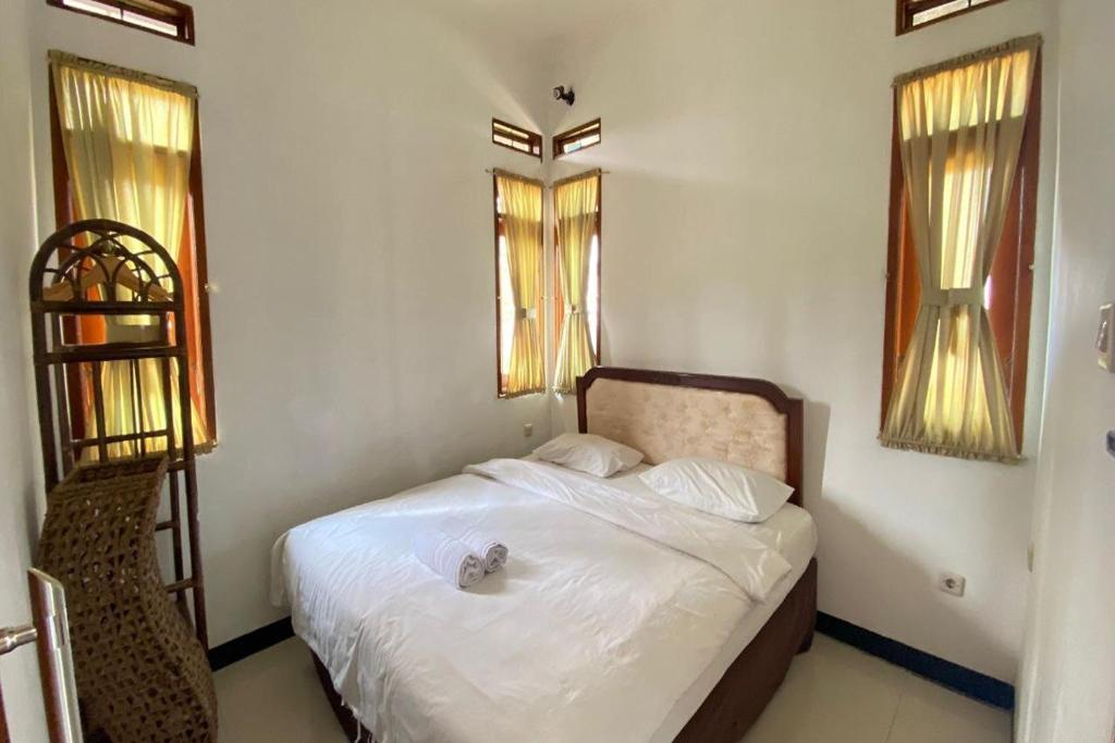Postel nebo postele na pokoji v ubytování Grand Nirwana Resort Lembang