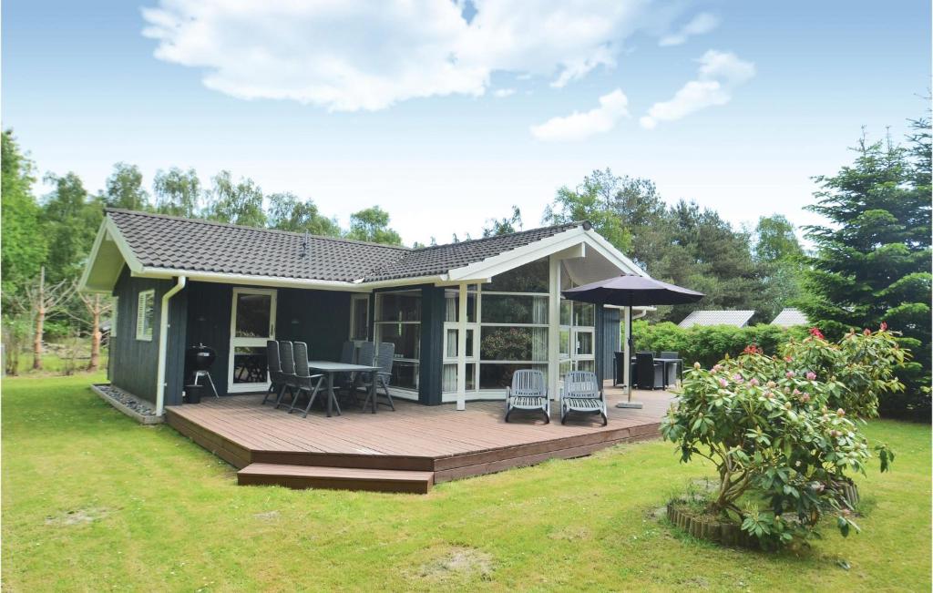 a house with a deck with a table and chairs at Holiday Home Krondyrstien Væggerløse Denm in Marielyst