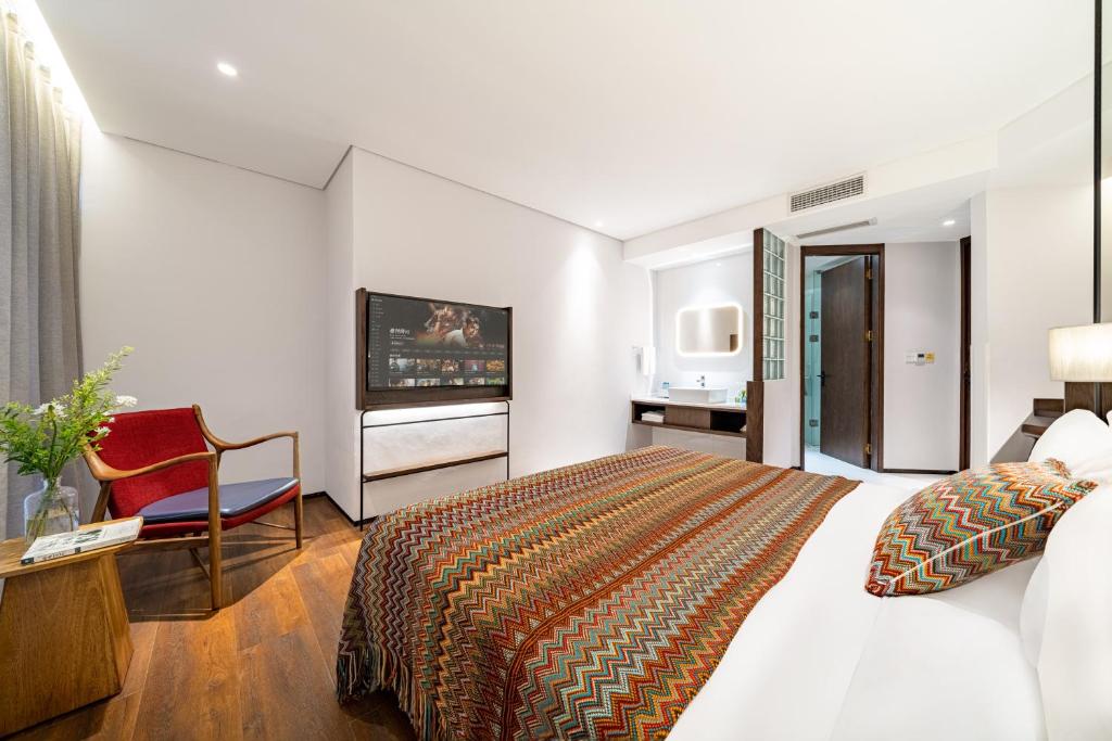 a hotel room with a bed and a television at Wuyu Hotel - Chongqing Jiangbei Airport & Light Rail in Chongqing