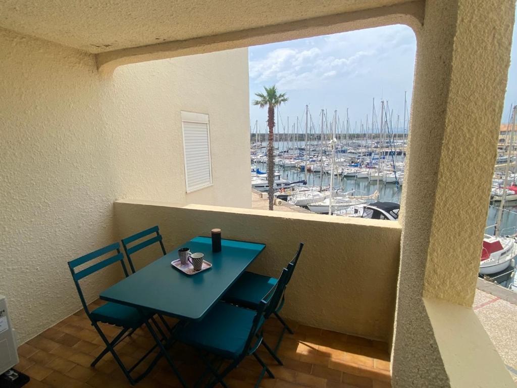 un balcon avec une table et des chaises et un port de plaisance dans l'établissement Port Leucate: T2 Alcove Climatisé, 6 Pers, Parking, Animaux bienvenus - FR-1-798-11, à Leucate