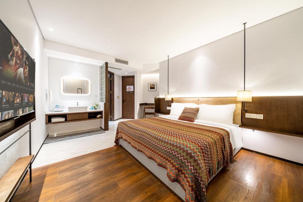 a bedroom with a large bed and a tv at Wuyu Hotel - Chongqing Jiangbei Airport & Light Rail in Chongqing