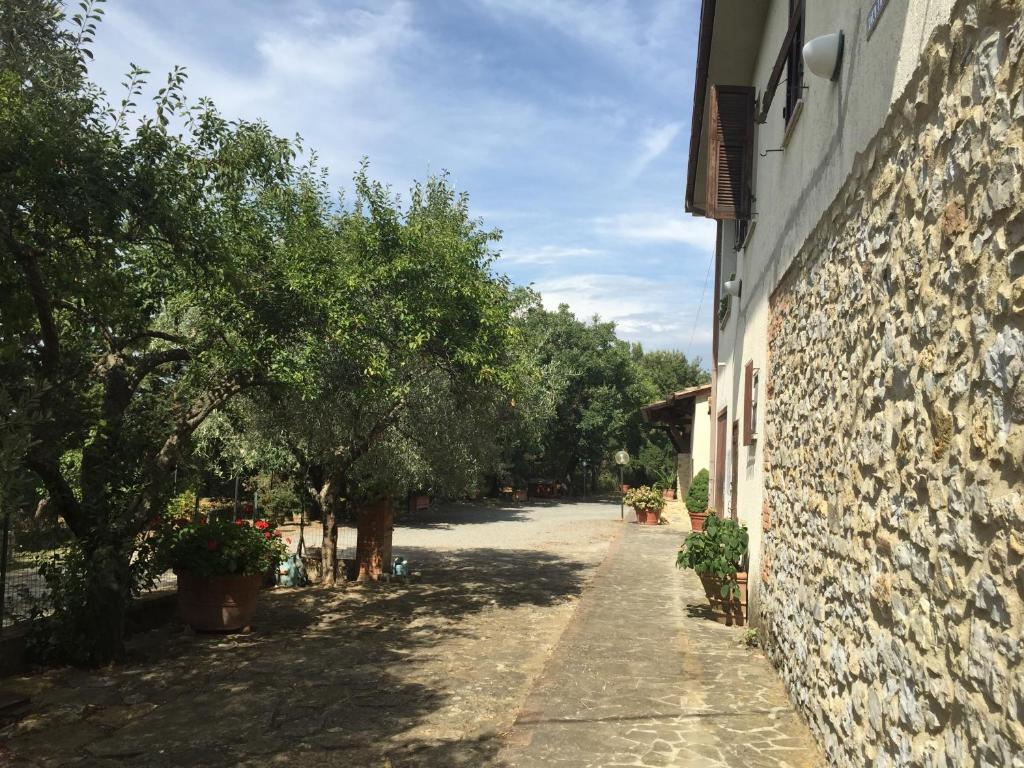 un callejón con árboles y un edificio de piedra en Agriturismo La Carletta, en Preselle
