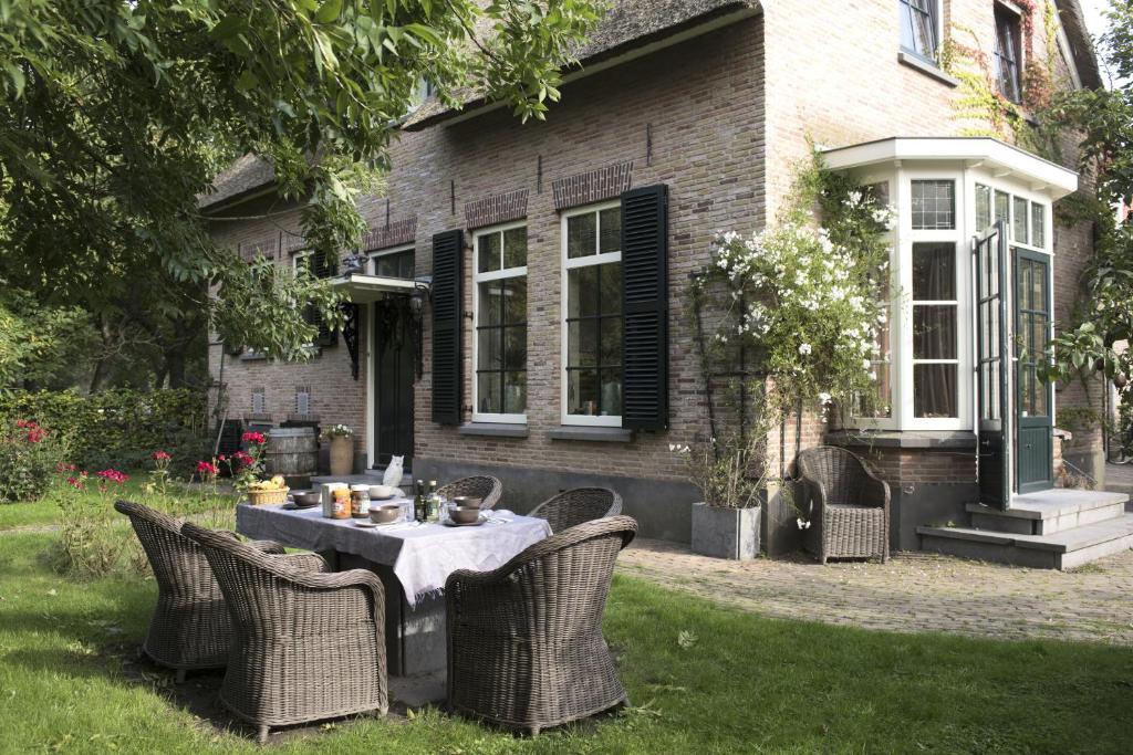 una mesa y sillas frente a una casa en Buitengoed De Uylenburg, en Delft