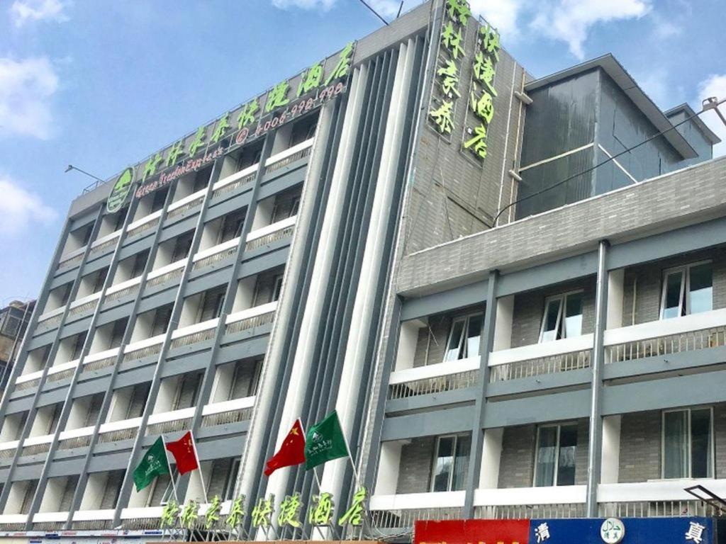 a large building with flags in front of it at GreenTree Inn Xuzhou Ruojia Express Hotel in Xuzhou