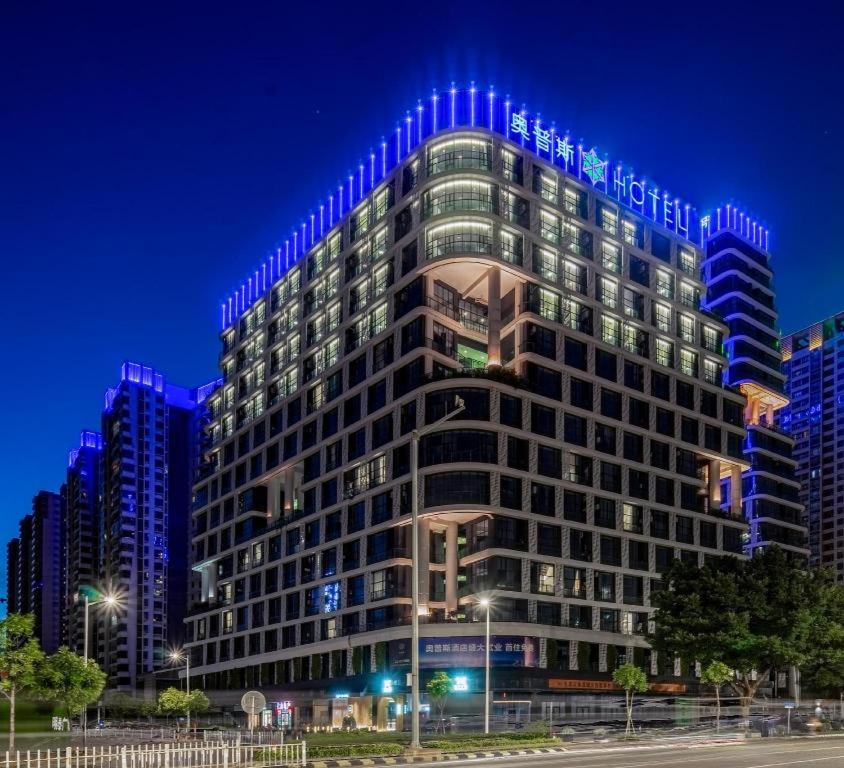 a large building with blue lights on top of it at Opus Hotel Jiangmen in Jiangmen