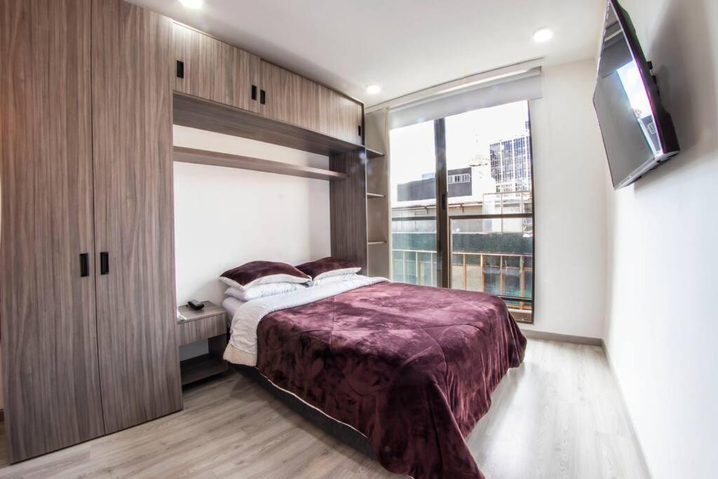 Chapinero Balcón fast Wifi Bares LGBTQ Theatron في بوغوتا: غرفة نوم بها سرير ونافذة كبيرة