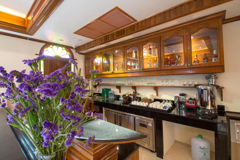 A wood-finished breakfast service counter with coffee equipment, cups and flowers.