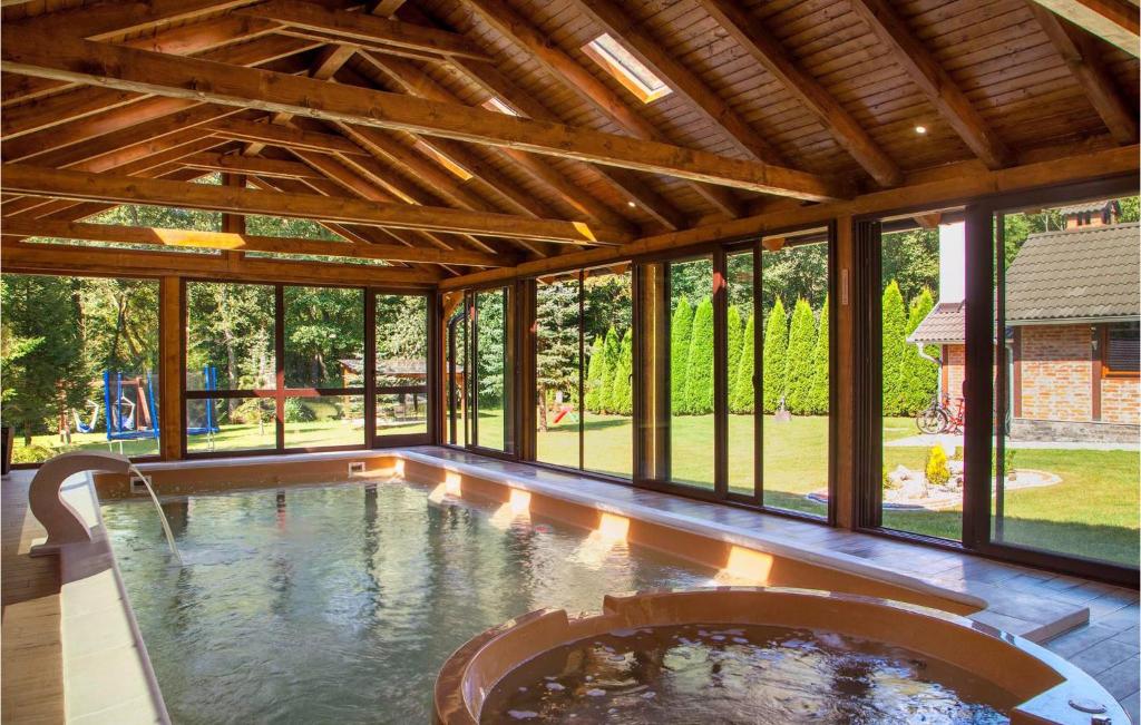 kryty basen z dużym pokojem z oknami w obiekcie Lovely Home In Novo Zvecevo With Sauna w mieście Novo Zvecevo
