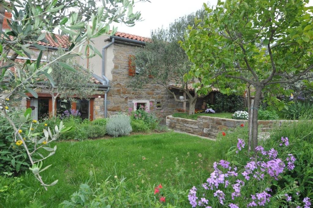a garden in front of a stone house at Ferienhaus für 4 Personen ca 100 qm in Nova Vas nad Dragonjo, Küstenland Slowenien in Nova Vas nad Dragonjo