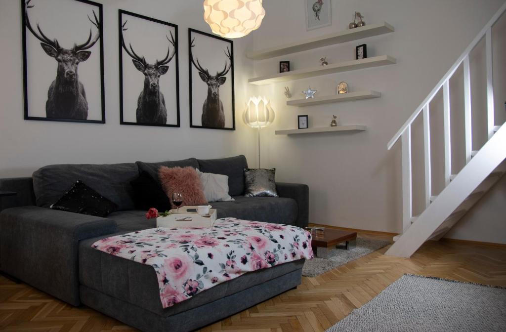 Hotel Downtown Apartment Budapest, a living room with a couch and some deer heads on the wall at Downtown Apartment Budapest in Budapest