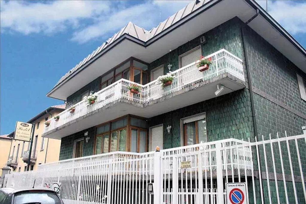 una casa verde con balcones blancos en una calle en Villamelchiorre 1, en Milán