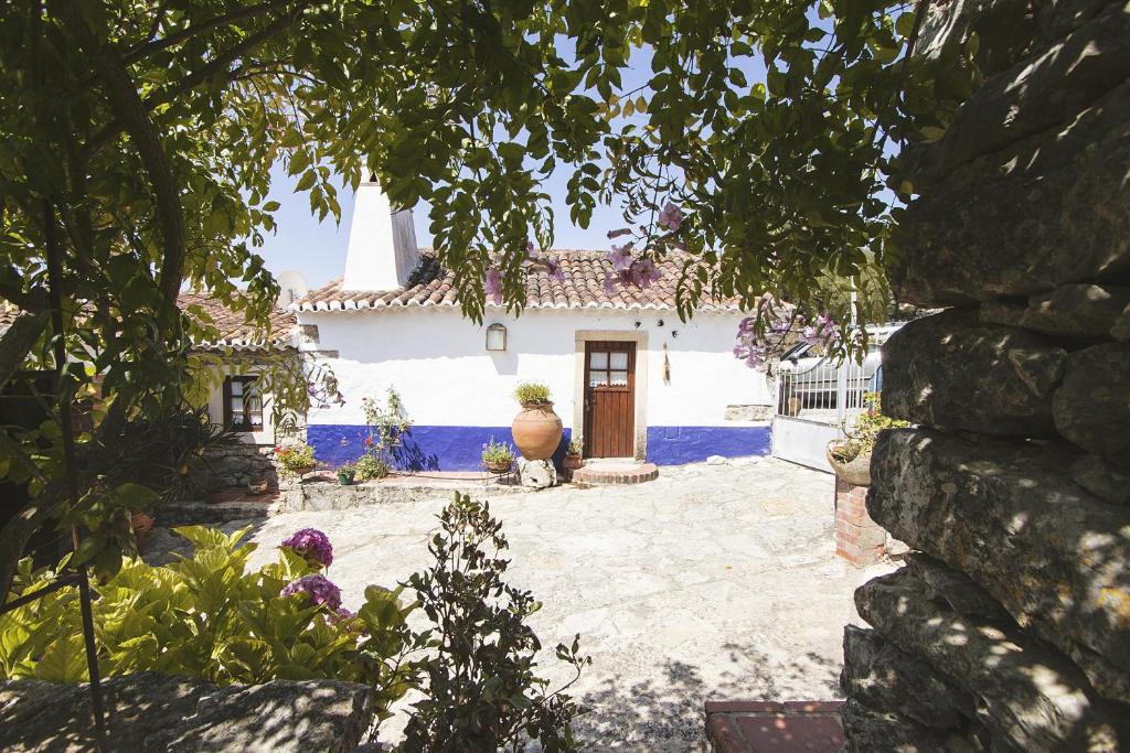 une maison blanche avec une porte dans une cour dans l'établissement Casa do Professor, à Casais dos Monizes