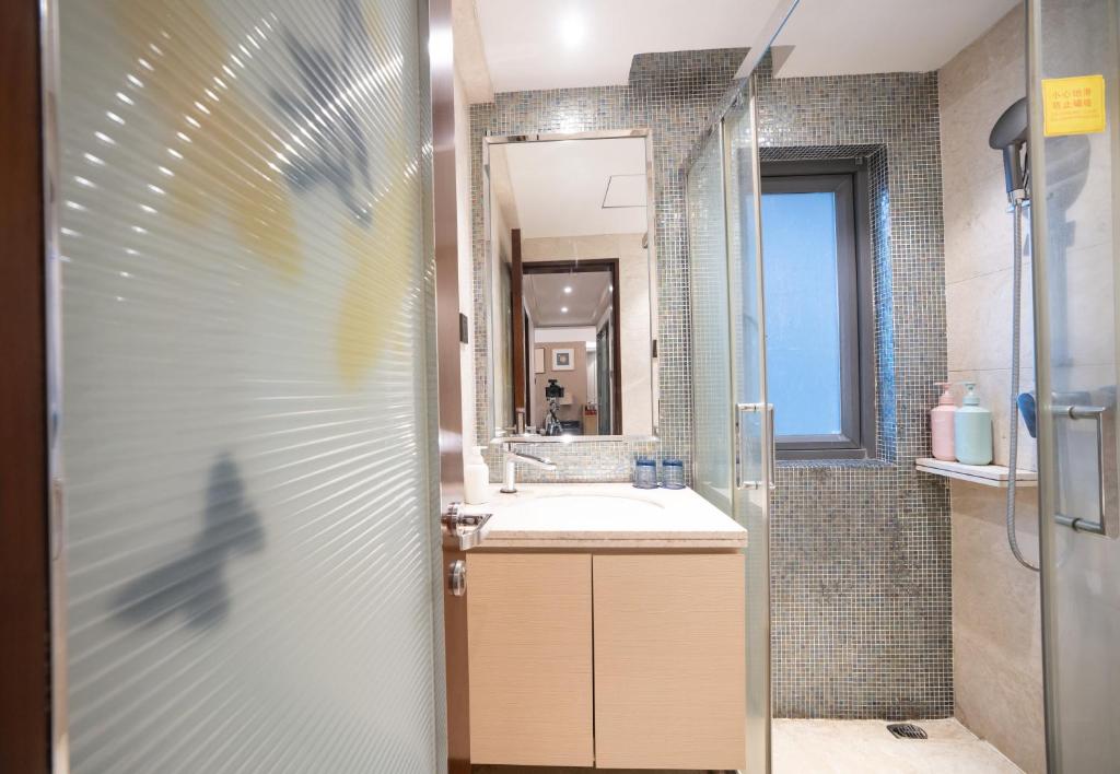 a bathroom with a sink and a mirror at Shenzhen Binhe Impression Hotel Apartments in Shenzhen