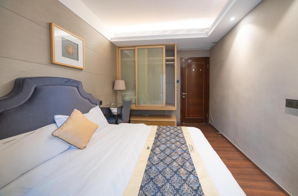 a bedroom with a large bed with a blue headboard at Shenzhen Binhe Impression Hotel Apartments in Shenzhen