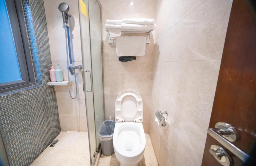 a small bathroom with a toilet and a shower at Shenzhen Binhe Impression Hotel Apartments in Shenzhen