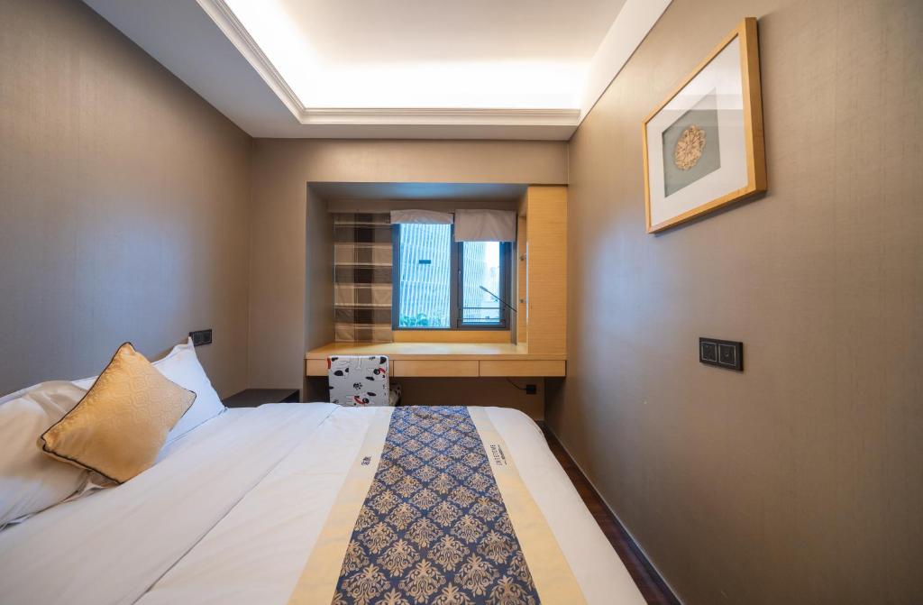 a small room with a bed and a window at Shenzhen Binhe Impression Hotel Apartments in Shenzhen