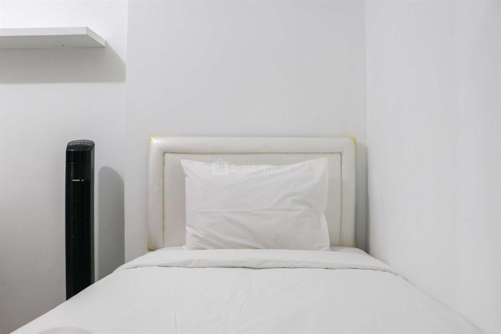 a white bed with a white pillow on it at Minimalist and Cozy 2BR at Gateway Pasteur Apartment By Travelio in Bandung