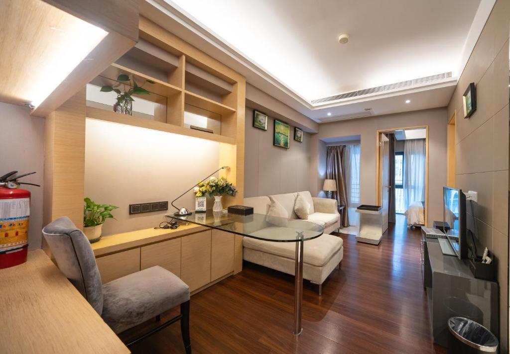 a living room with a table and a couch at Shenzhen Binhe Impression Hotel Apartments in Shenzhen