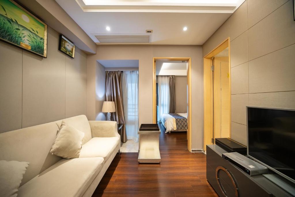 a living room with a couch and a tv at Shenzhen Binhe Impression Hotel Apartments in Shenzhen