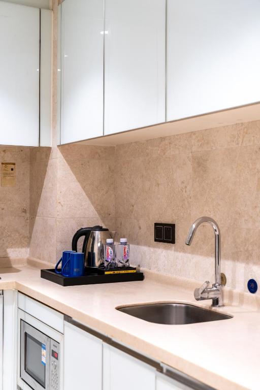a kitchen counter with a sink and a microwave at Shenzhen Binhe Impression Hotel Apartments in Shenzhen