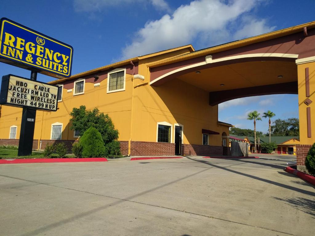 un edificio amarillo con un cartel delante en Regency Inn and Suites Galena Park, en Houston