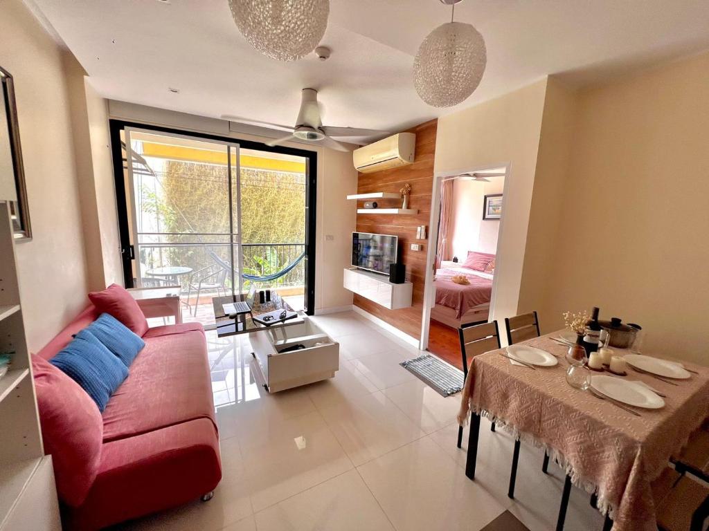 a living room with a red couch and a table at Appartement de 2 chambres à Naiharn Beach in Rawai Beach