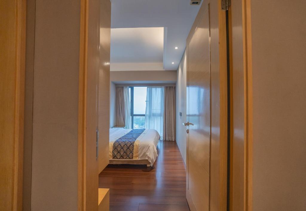 a bedroom with a bed and a window at Shenzhen Binhe Impression Hotel Apartments in Shenzhen