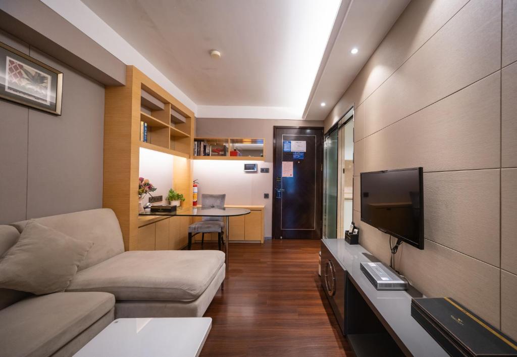 a living room with a couch and a flat screen tv at Shenzhen Binhe Impression Hotel Apartments in Shenzhen