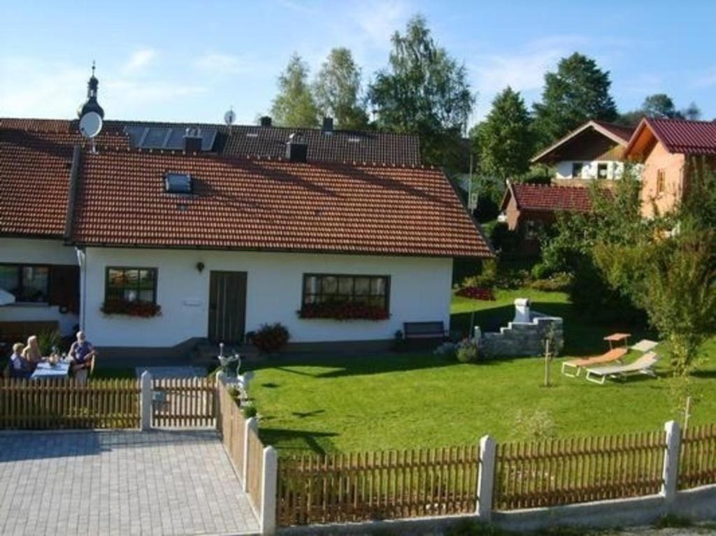 a white house with a fence and a yard at Geräumiges Ferienhaus in Rittsteig mit Terrasse, Garten und Grill in Lam