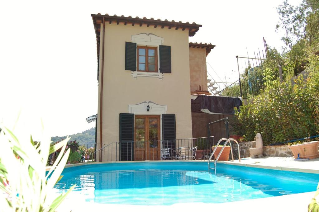a villa with a swimming pool in front of a house at Casa Ulqini in Bagni di Lucca